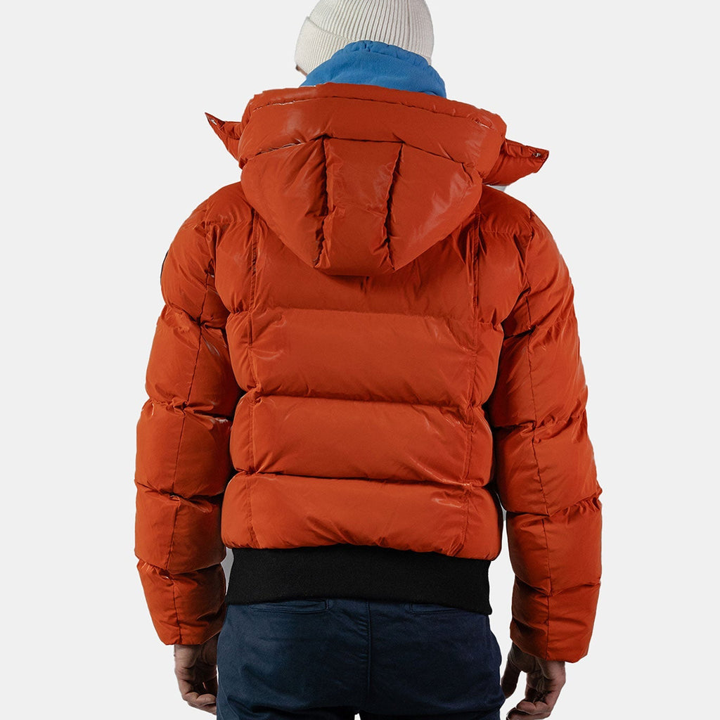 Woodpecker Men's Woody Bomber Winter coat. High-end Canadian designer winter coat for men in "All Wet Orange" colour. Woodpecker cruelty-free winter coat designed in Canada. Men's heavy weight short length premium designer jacket for winter. Superior quality warm winter coat for men. Moose Knuckles, Canada Goose, Mackage, Montcler, Will Poho, Willbird, Nic Bayley. Shiny parka. Stylish winter jacket. Designer winter coat.