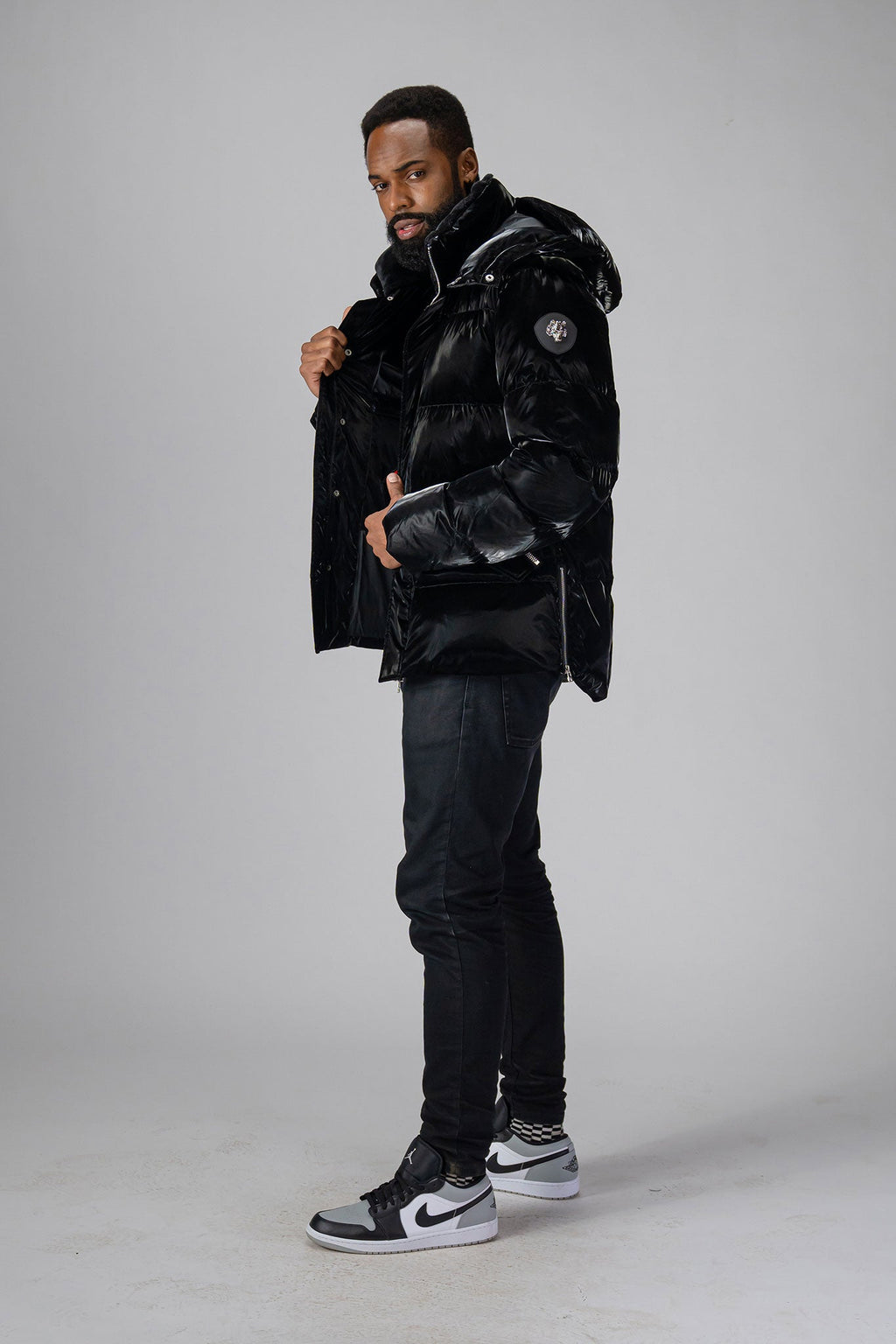 Woodpecker Men's Bumnester Winter coat. High-end Canadian designer winter coat for men in "All Wet Black" colour. Woodpecker cruelty-free winter coat designed in Canada. Men's heavy weight medium length premium designer jacket for winter. Superior quality warm winter coat for men. Moose Knuckles, Canada Goose, Mackage, Montcler, Will Poho, Willbird, Nic Bayley. Shiny parka. Stylish winter jacket. Designer winter coat.