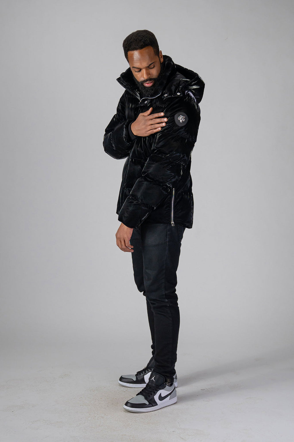 Woodpecker Men's Bumnester Winter coat. High-end Canadian designer winter coat for men in "All Wet Black" colour. Woodpecker cruelty-free winter coat designed in Canada. Men's heavy weight medium length premium designer jacket for winter. Superior quality warm winter coat for men. Moose Knuckles, Canada Goose, Mackage, Montcler, Will Poho, Willbird, Nic Bayley. Shiny parka. Stylish winter jacket. Designer winter coat.