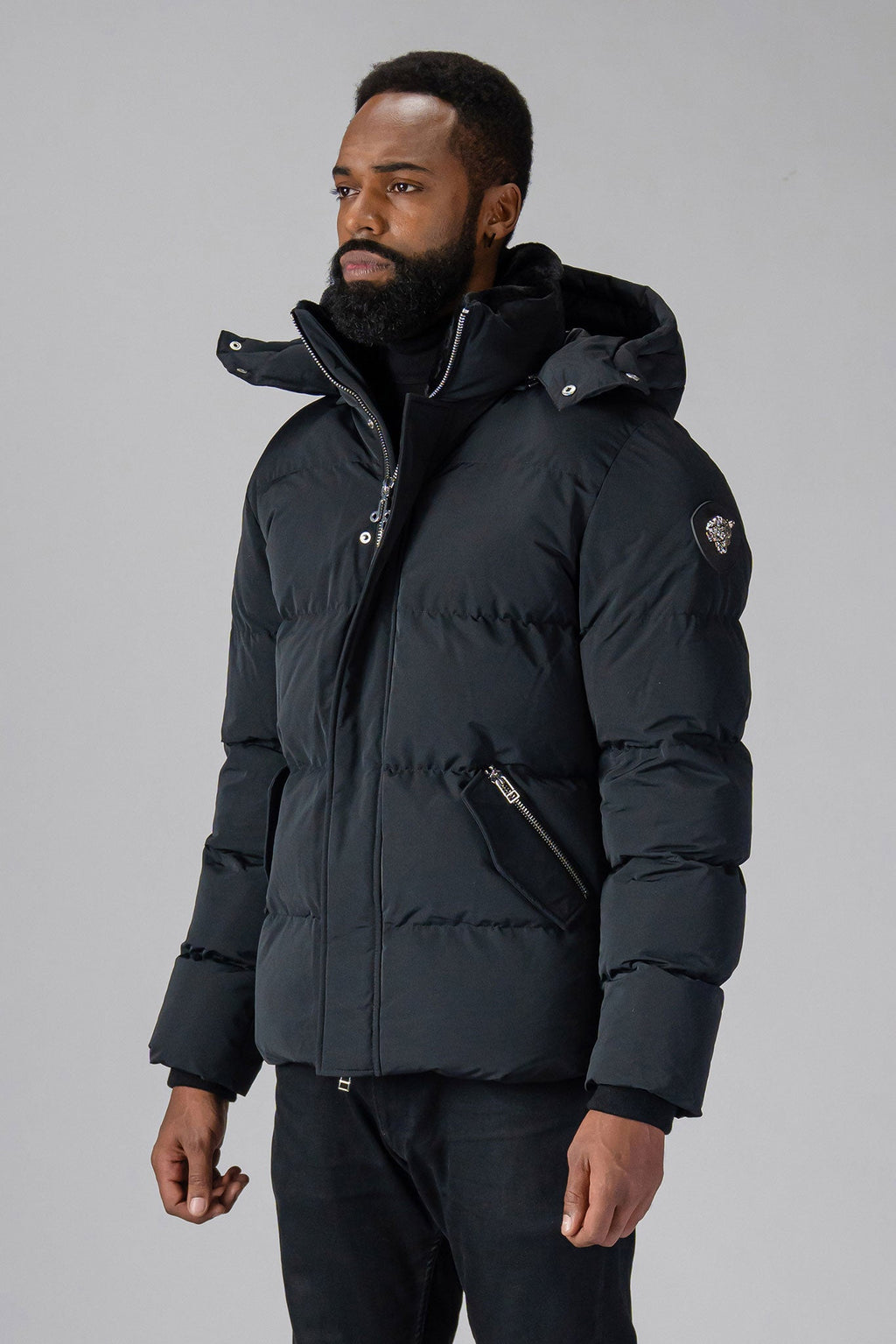 Woodpecker Men's Bumnester Winter coat. High-end Canadian designer winter coat for men in "Matte Black" colour. Woodpecker cruelty-free winter coat designed in Canada. Men's heavy weight medium length premium designer jacket for winter. Superior quality warm winter coat for men. Moose Knuckles, Canada Goose, Mackage, Montcler, Will Poho, Willbird, Nic Bayley. Shiny parka. Stylish winter jacket. Designer winter coat.