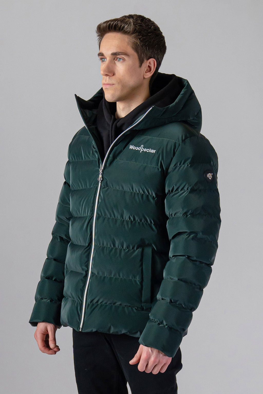 Woodpecker Men's Sparrow Winter coat. High-end Canadian designer winter coat for men in "Green Diamond" colour. Woodpecker cruelty-free winter coat designed in Canada. Men's medium weight medium length premium designer jacket for winter. Superior quality warm winter coat for men. Moose Knuckles, Canada Goose, Mackage, Montcler, Will Poho, Willbird, Nic Bayley. Shiny parka. Stylish winter jacket. Designer winter coat.