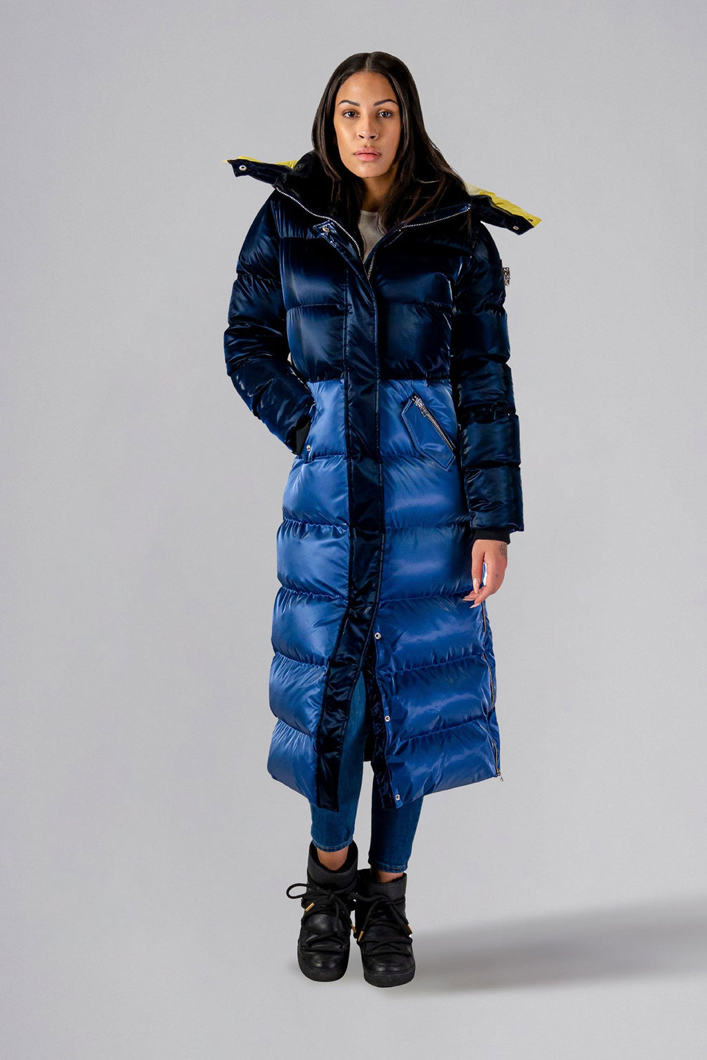 Woodpecker Women's Extra Long Bird of Paradise Winter coat. High-end Canadian designer winter coat for women in “Blue Yellow" colour. Woodpecker cruelty-free winter coat designed in Canada. Women's heavy weight extra long length premium designer jacket for winter. Superior quality warm winter coat for women. Moose Knuckles, Canada Goose, Mackage, Montcler, Will Poho, Willbird, Nic Bayley. Extra warm. Shiny parka. Stylish winter jacket. Designer winter coat.