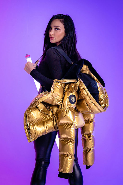 winter coat for women in shiny "Gold" colour. Woodpecker cruelty-free winter coat designed in Canada. Women's heavy weight medium length premium designer jacket for winter. Superior quality warm winter coat for women. Moose Knuckles, Canada Goose, Mackage, Montcler, Will Poho, Willbird, Nic Bayley. Extra warm. Shiny parka. Stylish winter jacket. Designer winter coat.